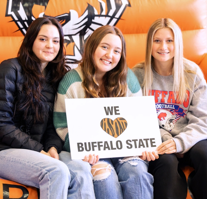 Three students holding a sign
