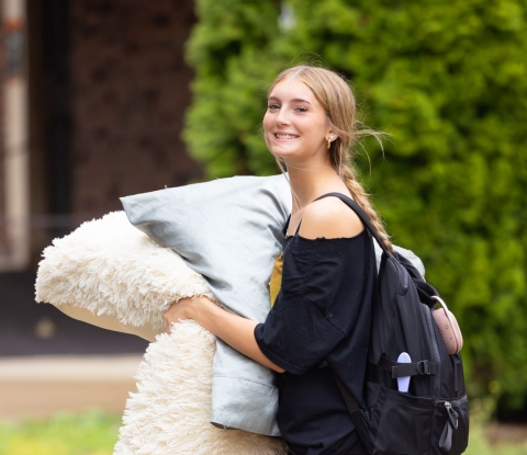 Student carrying pillows