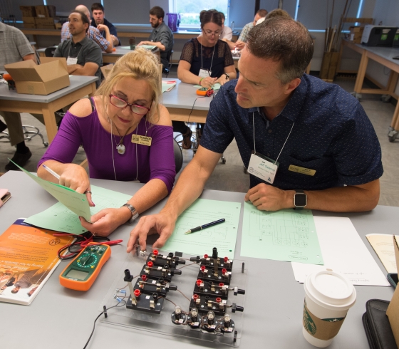 Two teachers sit and work together on a science activity